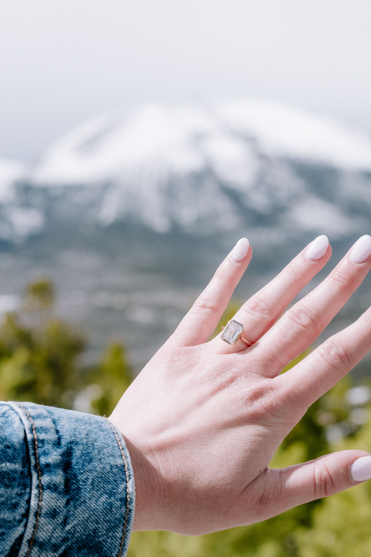 Engagement ring sparkling with snowy mountains in the background